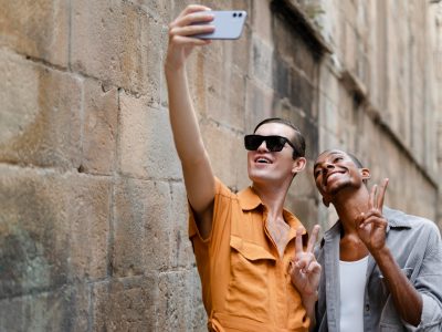 A travel influencer taking a selfie with a scenic mountain backdrop while holding a smartphone with Instagram open.