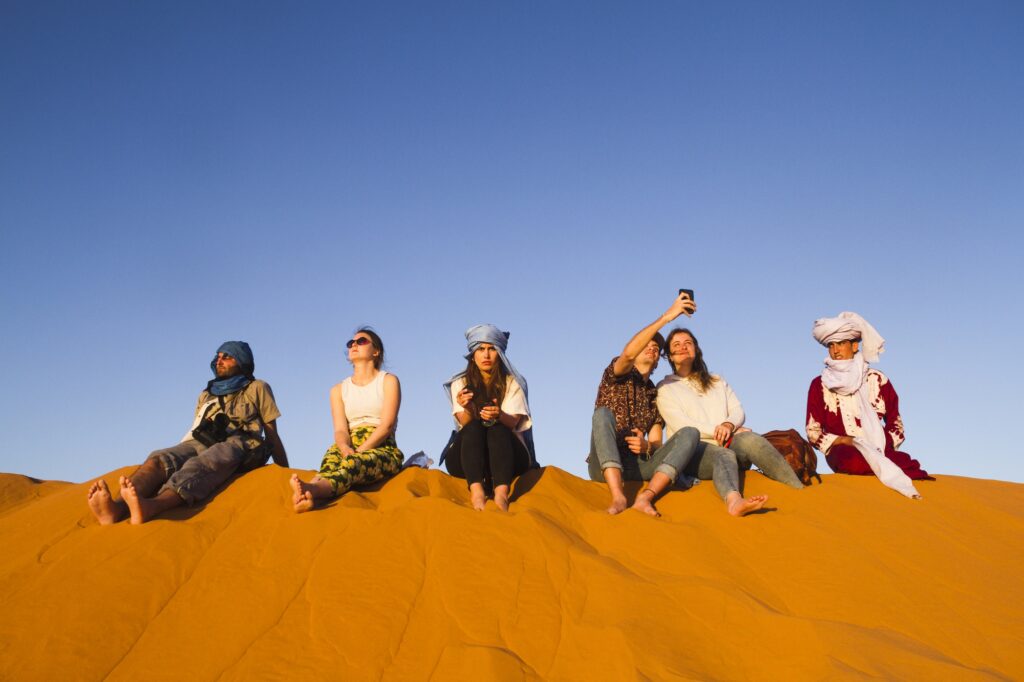 group people sitting top dune 1